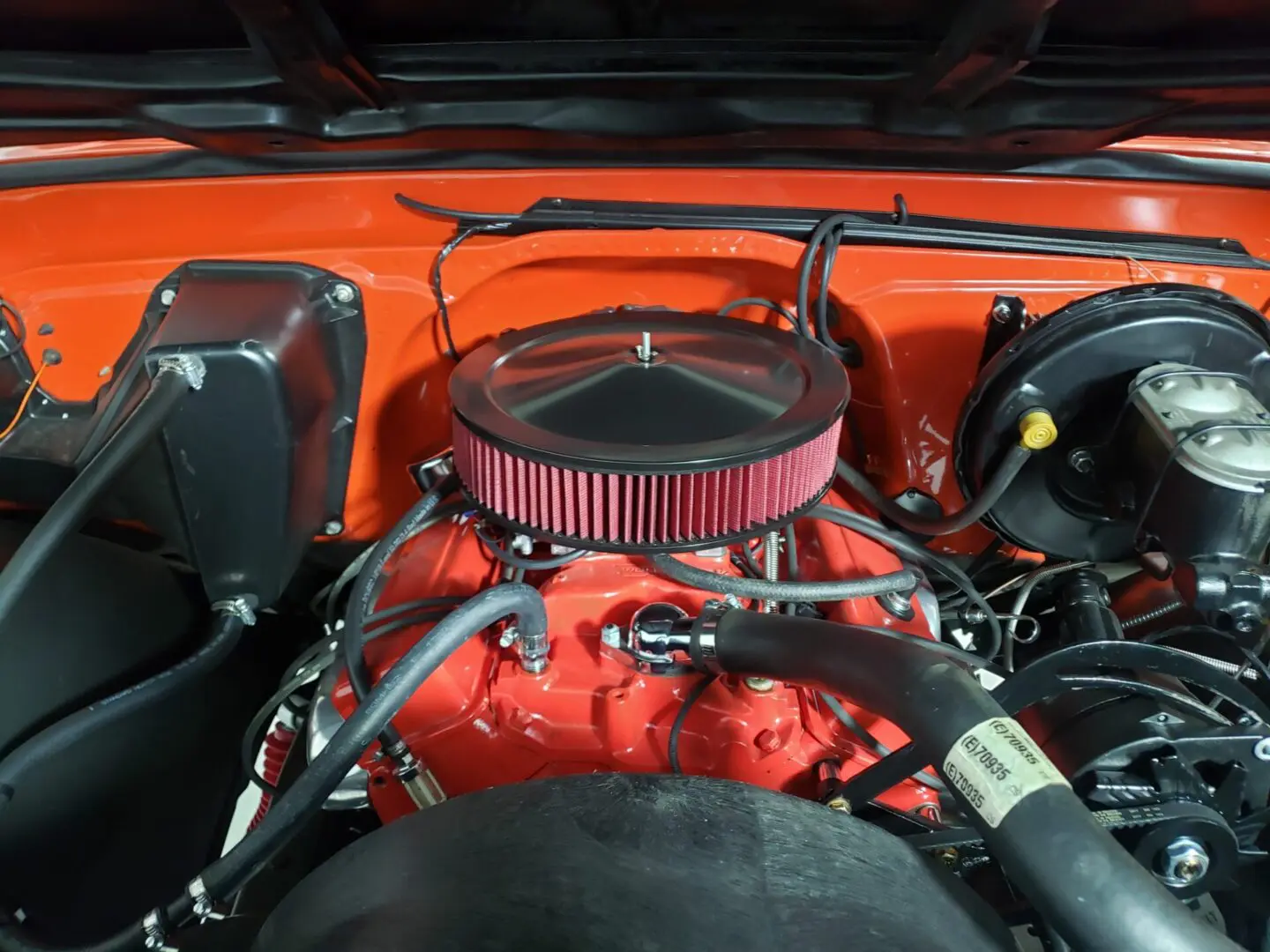 A close up of the engine compartment of an orange truck.