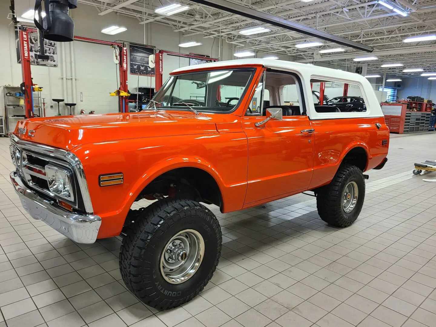 A red and white truck is parked in a showroom.