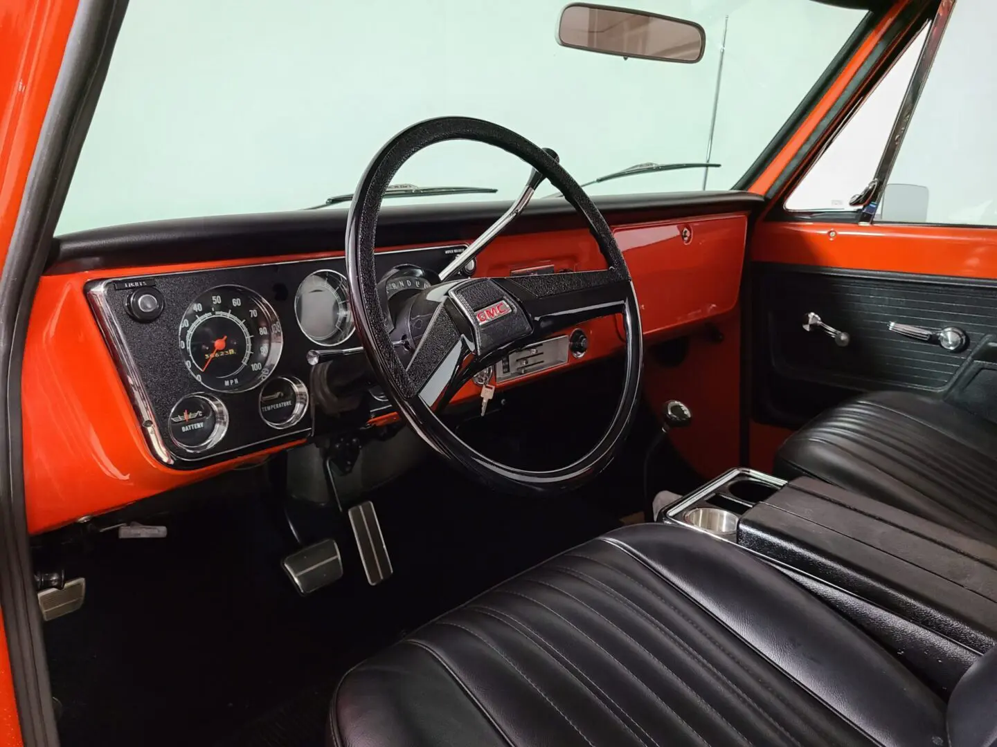 A red truck with black seats and steering wheel.