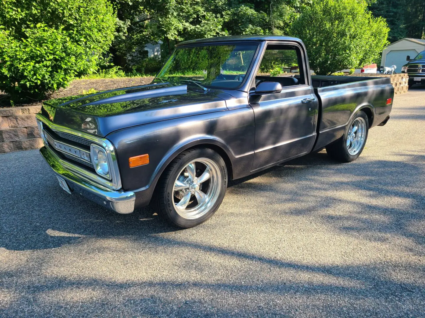 A black truck parked in the middle of a driveway.