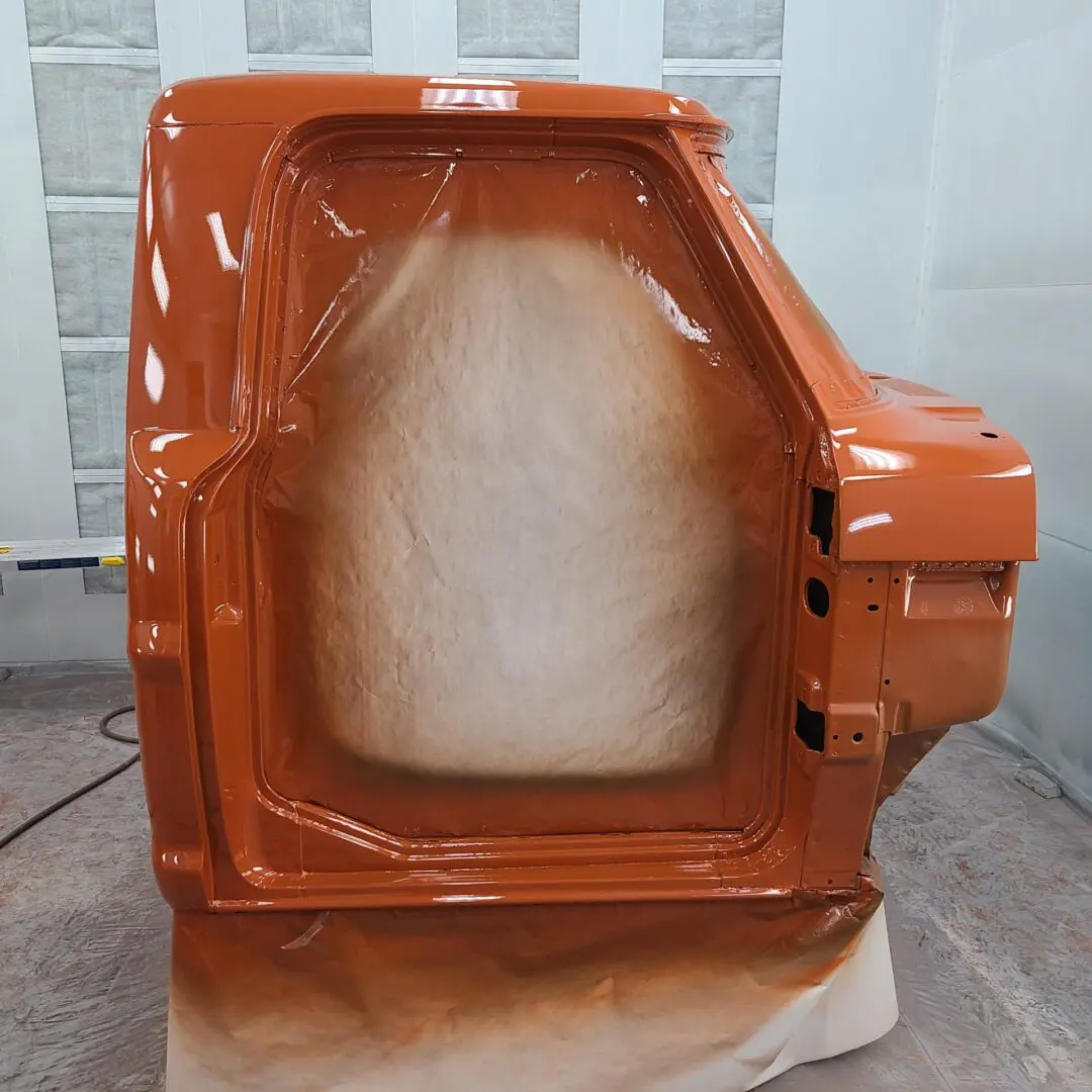 A picture of an orange door with some white paint.