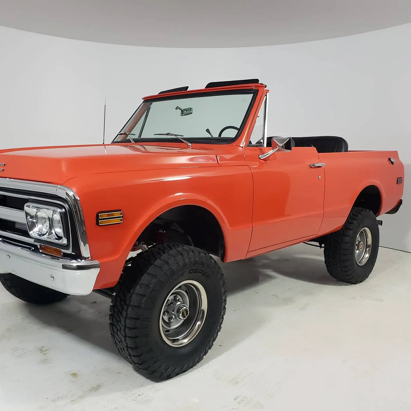 A red truck is parked in the corner of a room.