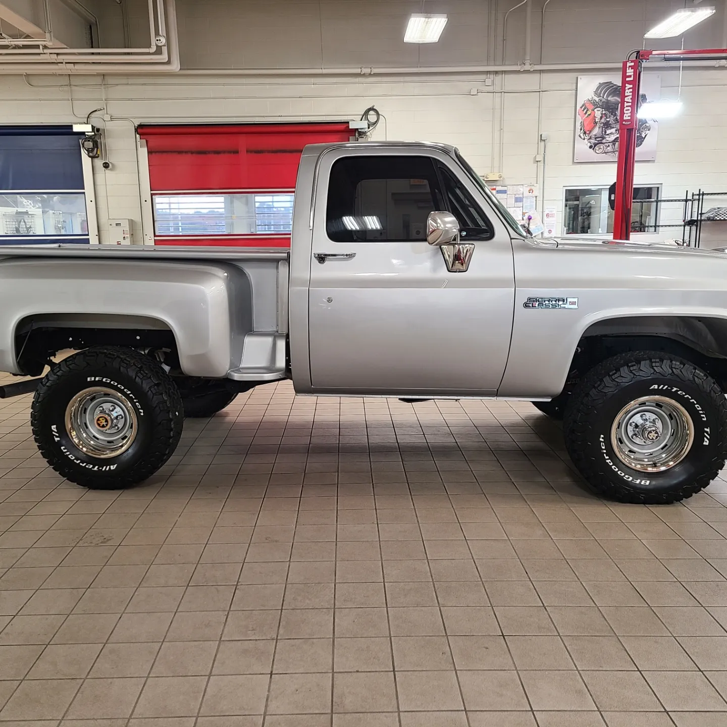 A silver truck is parked in a garage.